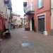 Usciamo dal bar e abbandoniamo via Dante, imboccando sulla destra la stretta via Felice Cavallotti. Siamo nel centro storico, una zona dominata da case basse col tetto spiovente e i muri generalmente rosa